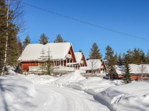 a house covered in snow next to a road at Holiday Home Iso kiiruna by Interhome in Hyrynsalmi