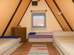 1 dormitorio en el ático con 2 camas y ventana en Chalet Kamilla by Interhome en Balatonmáriafürdő