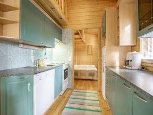 een keuken met blauwe kasten en een tapijt op de vloer bij Holiday Home Honkalinna by Interhome in Isojoki