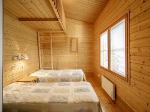 een slaapkamer met 2 bedden in een houten hut bij Holiday Home Honkalinna by Interhome in Isojoki