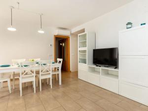 a kitchen and dining room with a table and a tv at Apartment Blue Tossa by Interhome in Tossa de Mar