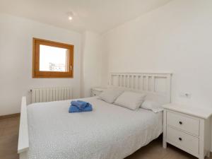 濱海托薩的住宿－Apartment Blue Tossa by Interhome，一间卧室配有一张白色的床,上面有蓝色的毛巾