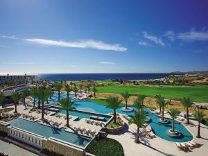 a beach with a pool, chairs, and a pool table at Secrets Puerto Los Cabos Golf & Spa18+ in San José del Cabo
