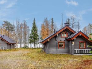 a log cabin in the woods next to a fence at Holiday Home Lomaväinö 13 by Interhome in Salla