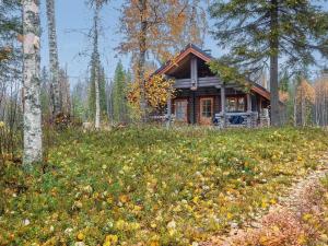 a log cabin in the woods next to a dirt road at Holiday Home Lomaväinö 13 by Interhome in Salla