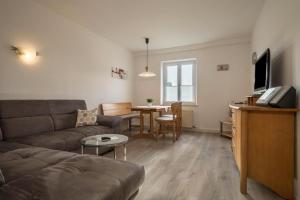 ein Wohnzimmer mit einem Sofa und einem Tisch in der Unterkunft Ferienwohnung Höscheler Groß in Lindau-Bodolz