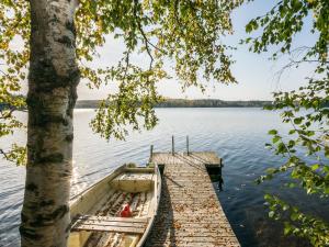 a boat tied up to a dock on a lake at Holiday Home Miilu by Interhome in Iitti