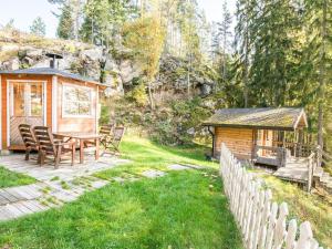 a wooden cabin with a table and a gazebo at Holiday Home Miilu by Interhome in Iitti