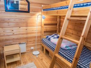 ein Schlafzimmer mit Etagenbetten in einem Blockhaus in der Unterkunft Holiday Home Vuosselin kuukkeli by Interhome in Virkkula