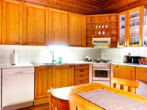 エノンテキエにあるHoliday Home Riekkotupa by Interhomeのキッチン(木製キャビネット、木製テーブル付)