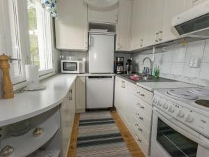 eine Küche mit weißen Schränken und weißen Geräten in der Unterkunft Holiday Home Salmiranta by Interhome in Jämijärvi