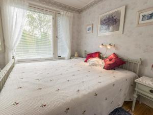 Schlafzimmer mit einem Bett mit roten Kissen und einem Fenster in der Unterkunft Holiday Home Salmiranta by Interhome in Jämijärvi