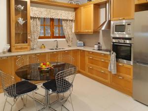 una cocina con armarios de madera y una mesa con sillas. en Holiday Home Ca Romeu by Interhome, en Alcover