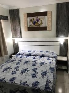 1 dormitorio con 1 cama con edredón azul y blanco en Via Caldas L'acqua V, en Caldas Novas