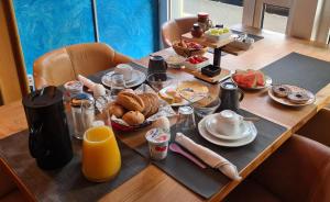 a wooden table with breakfast foods on it at Hotel Aleo in Bochum