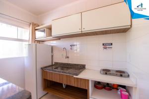 cocina con fregadero y nevera en Apartamento Via Caldas L'Acqua II, en Caldas Novas