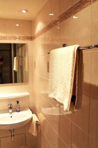 a bathroom with a sink and a shower with a towel at Hotel-Landgasthof Grüner Baum - Dittigheim in Tauberbischofsheim