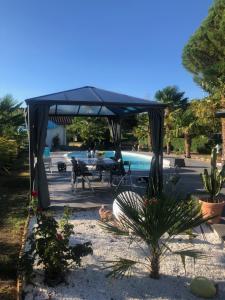 a blue canopy over a patio with a pool at Villa Bergerac avec Piscine in Bergerac