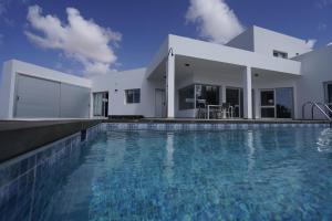 a large swimming pool in front of a house at Casa Achaman - Contemporary style villa with outstanding views in Tindaya