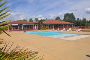 - une piscine avec des chaises et une maison dans l'établissement Nid Douillet, à Poncins