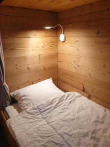 a bed in a room with a wooden wall at Le lodge by Lilou in Manigod