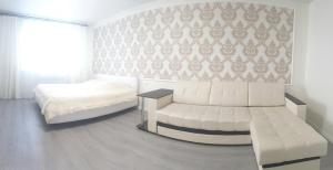 ヤロスラヴリにあるApartment on Radishcheva 10/12のベッドルーム(ベッド1台、白いソファ付)