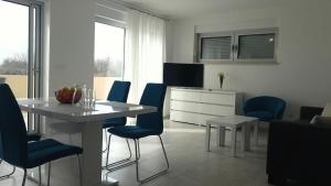 a kitchen with a dining table and blue chairs at Apartment Janja in Medulin