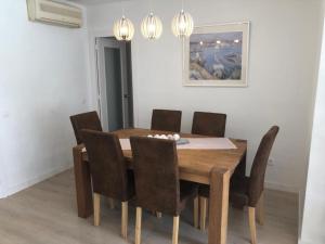 a dining room with a wooden table and chairs at BLANES APARTAMENTO in Blanes +13 photos