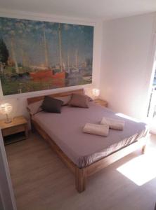 a bedroom with a bed with a painting on the wall at BLANES APARTAMENTO in Blanes