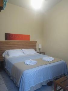 a bedroom with a bed with two towels on it at Pousada Presidente in Diamantina