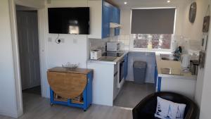 a small kitchen with blue cabinets and a counter top at Chalet Bayside in Sandown