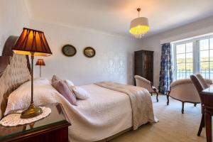 a bedroom with a bed and a table with a lamp at Shearwater Country House Accommodation in Union Hall