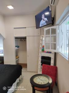 Habitación pequeña con TV en la pared y mesa. en Zona centrica dentro de las cuatro avenidas. en Santiago del Estero