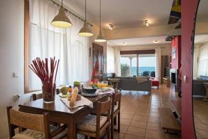 Maistro Beach House في أكارافي: غرفة طعام وغرفة معيشة مع طاولة وكراسي