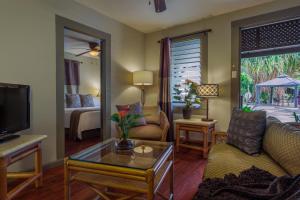 ein Wohnzimmer mit einem Sofa und einem TV in der Unterkunft Paradise Bay Resort in Kaneohe