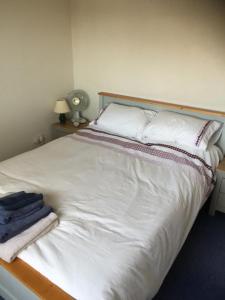 a bedroom with a white bed with towels on it at JOE'S PLACE in Retford