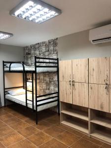 Cette chambre comprend 2 lits superposés et des placards en bois. dans l'établissement Хостел Lime, à Dnipro
