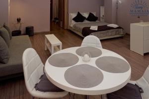 Habitación con mesa blanca, sillas y cama en Ady's Studio en Mamaia