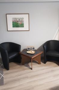 a living room with two chairs and a coffee table at Pension K61 Sylke und Michael Paffrath in Gebesee