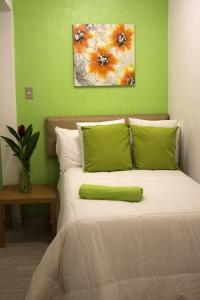 a bedroom with a bed with a green wall at Super Precio in Guatemala