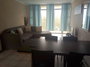 a living room with a couch and a table at Strandburg Holiday Apartments in Amanzimtoti