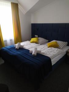 a large bed with yellow and blue sheets and yellow pillows at Dom Przyjęć Pradziad in Rogów