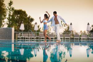 a bride and groom dancing next to a swimming pool at Laguna Park Hotel 4Superior in Bibione