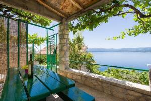 a patio with a table and a view of the water at Vineyard Cottages - Murvica (146) in Murvica