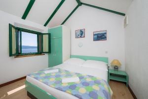 a bedroom with a bed in a room with a window at Vineyard Cottages - Murvica (146) in Murvica