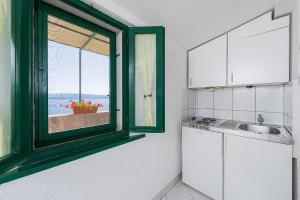 a kitchen with a green window and a sink at Vineyard Cottages - Murvica (146) in Murvica +75 photos