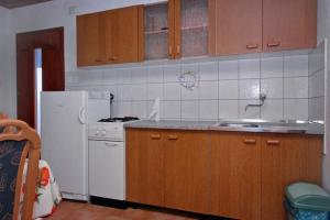 La cuisine est équipée d'un réfrigérateur blanc et d'un évier. dans l'établissement Apartment Basina (3450-2), à Stari Grad
