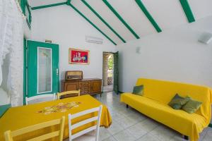 a living room with a yellow couch and a table at Vineyard Cottages - Murvica (146) in Murvica