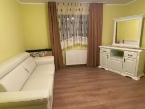 ein Wohnzimmer mit einem weißen Sofa und einem Spiegel in der Unterkunft Casa Diana&Ovi in Câmpulung Moldovenesc