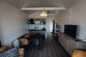 a room with a table and chairs and a kitchen at Logeren aan Zee in Katwijk aan Zee